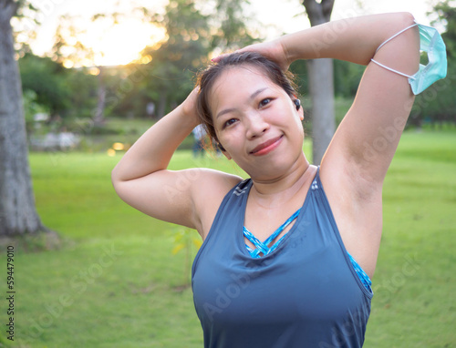 Portrait of a beautiful Asian woman in sportswear, standing with her back, stretching before exercising outdoor in the park in the morning to achieve a healthy lifestyle. healthy warming up
