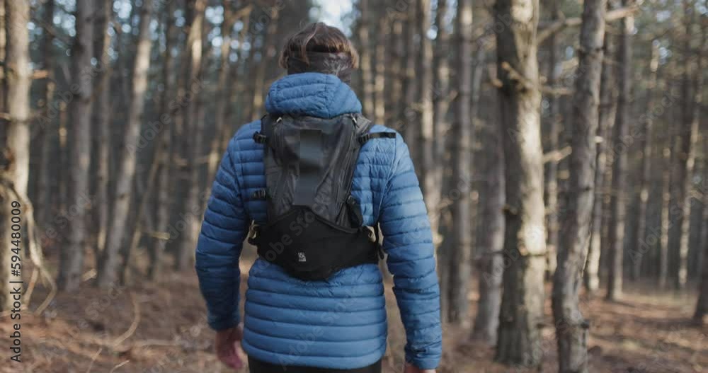 Man walking in a beautiful forest during cold winter day. Back view. Sun shining between trees. Recorded at 120 fps. Man walking in a beautiful forest during cold winter day. Back view. Sun shining between trees. Recorded at 120 fps.