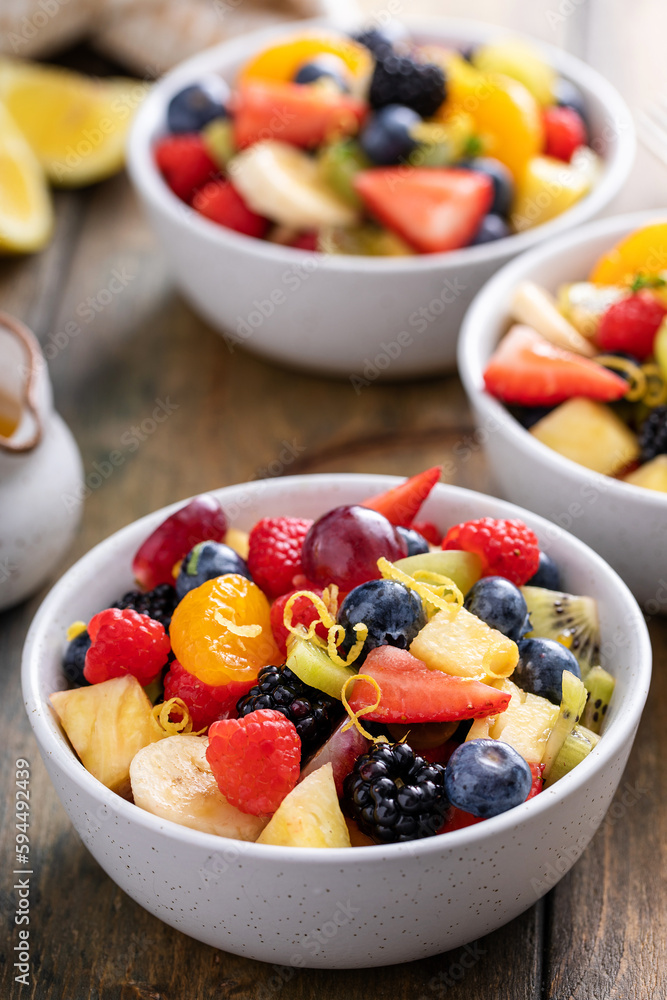 Fruit salad on a wooden table with berries and honey dressing Fruit salad on a wooden table with berries and honey dressing
