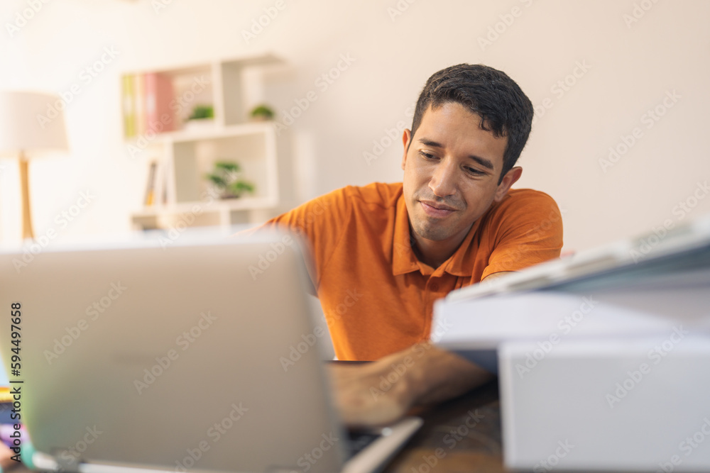 Man working with a laptop sitting in a home office Man working with a laptop sitting in a home office