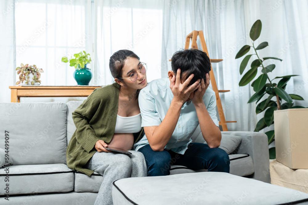 Asian husband covering his face worried about financial problems