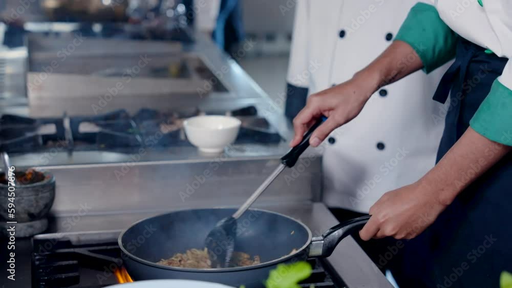 4K Slow, Close-up food being stirred in pan along with fire that is ignited by techniques skilled chefs, who created this menu, chef holds handle pan firmly cooks food by using spatula mix well. 4K Slow, Close-up food being stirred in pan along with fire that is ignited by techniques skilled chefs, who created this menu, chef holds handle pan firmly cooks food by using spatula mix well.