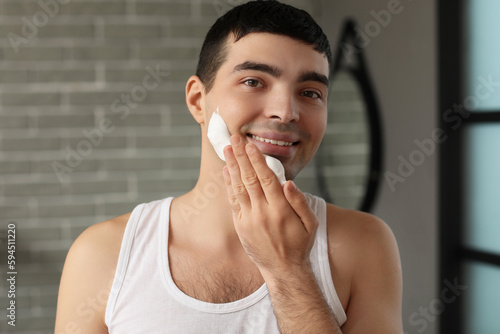Young man applying shaving ...
