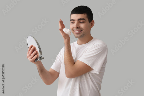 Young man applying shaving ...