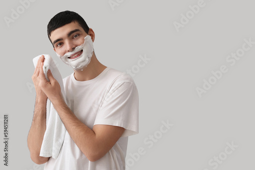 Young man wiping shaving fo...