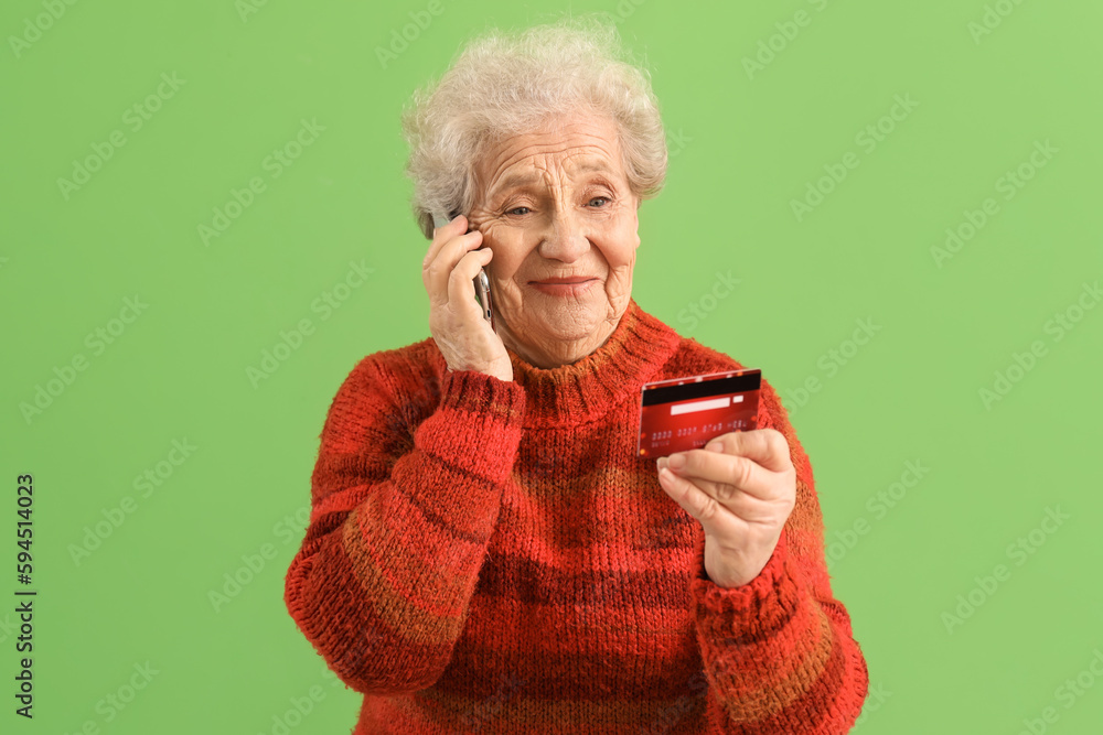 Senior woman with credit card talking by mobile phone on green background Senior woman with credit card talking by mobile phone on green background