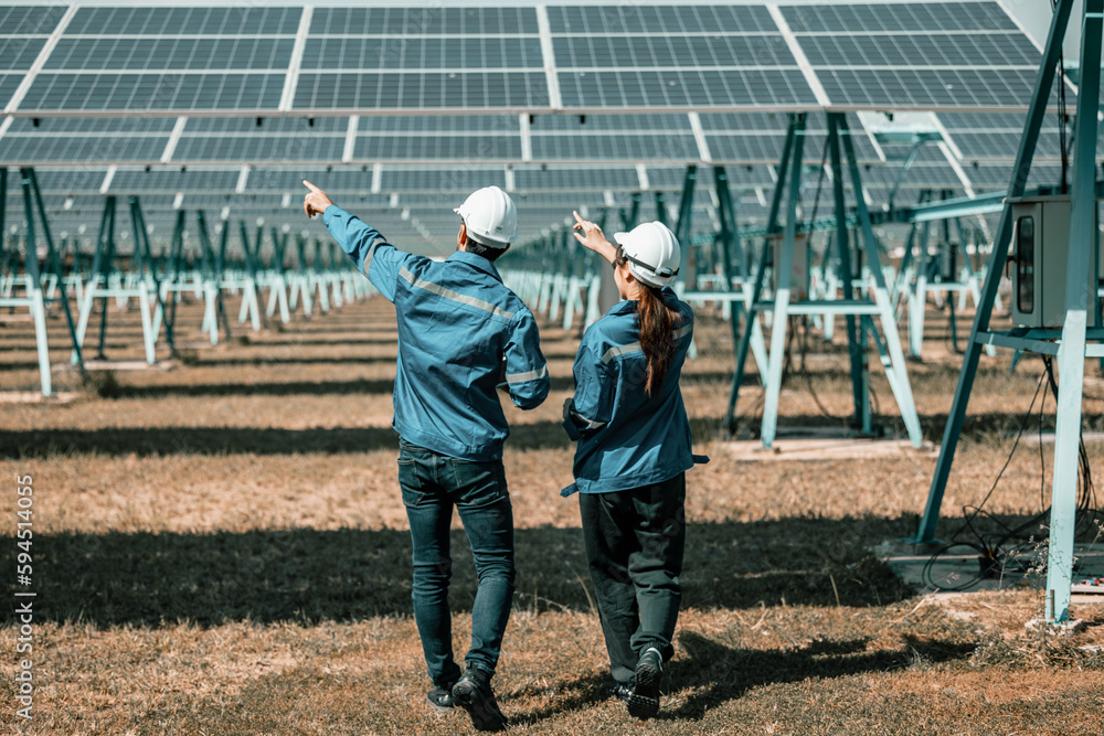Solar design engineers visually inspect photovoltaic array installation ...