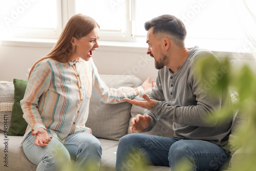 Angry young couple quarreling at home. Domestic violence concept