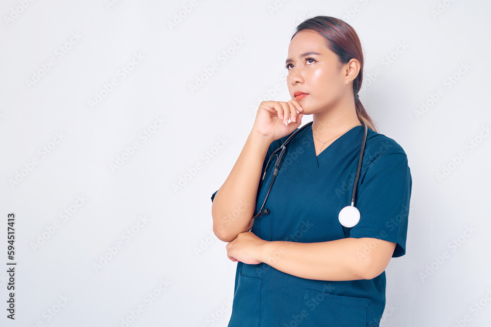 Thoughtful young Asian female professional nurse working wearing a blue uniform thinking and decision being solving disease case in a hospital isolated on white background. Healthcare medicine concept Thoughtful young Asian female professional nurse working wearing a blue uniform thinking and decision being solving disease case in a hospital isolated on white background. Healthcare medicine concept