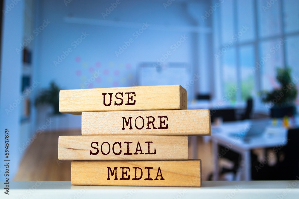 Wooden blocks with words 'USE MORE SOCIAL MEDIA'. Business concept