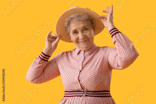 Senior woman in hat on yell...