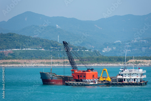Floating crane working as a dredger near Chinese sea coast. photo