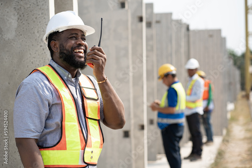 Portrait African American engineer man working with walkie talkie at precast cement factory background 
