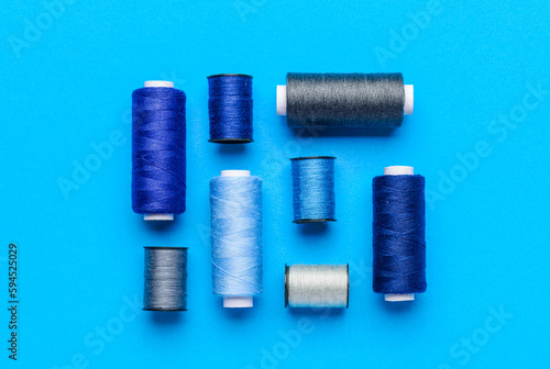 Composition with different thread spools on color background