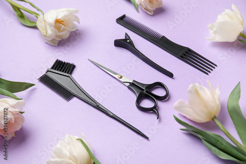 Composition with hairdresser tools and tulip flowers on lilac background