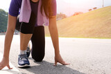Active healthy woman tying running shoes,  jogging runner healthcare and well being concept.