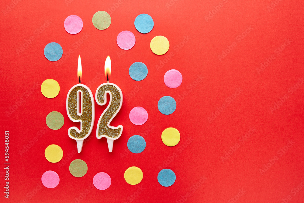 Number 92 on a red background with colored confetti. Happy birthday candles. The concept of celebrating a birthday, anniversary, important date, holiday. Copy space. banner Number 92 on a red background with colored confetti. Happy birthday candles. The concept of celebrating a birthday, anniversary, important date, holiday. Copy space. banner