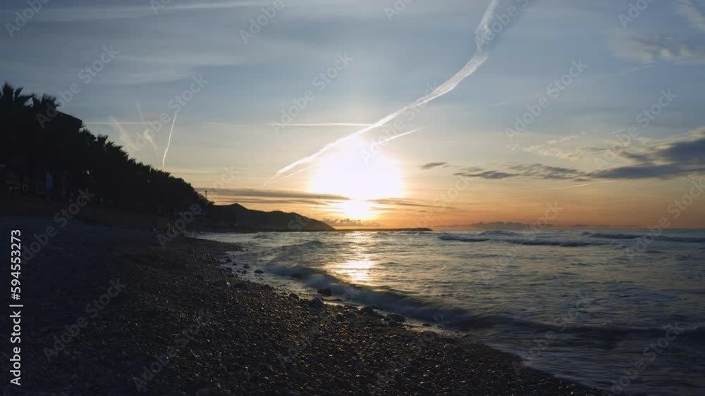 Beautiful Time Lapse of Sunrise on a Peaceful Stoney Beach as clouds rush by Beautiful Time Lapse of Sunrise on a Peaceful Stoney Beach as clouds rush by