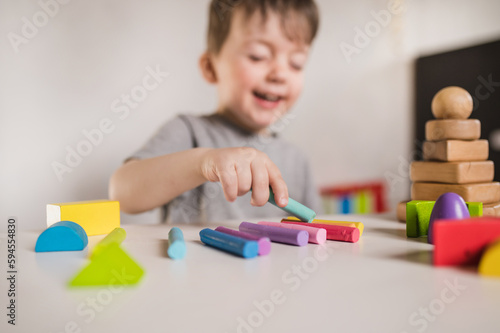 Happy boy play with plastiline and constructor. Kids hands with colorful clay. Close up.  Early childhood development and behavior modification. Finger sensory therapy and speech therapist