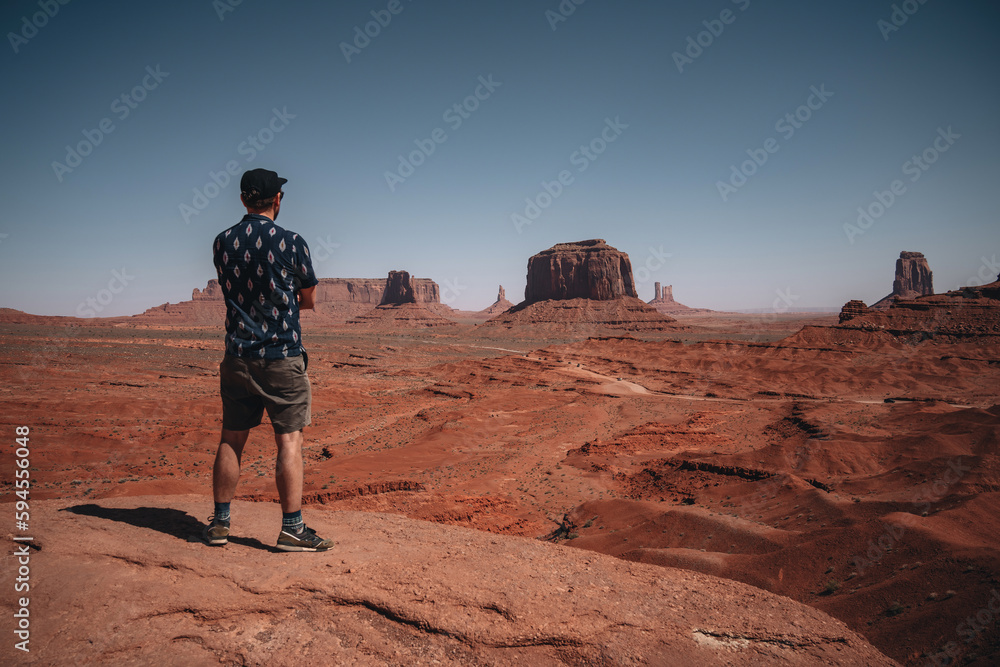 Tourist admiring view with of Monument Valley with mittens butte in the background. Travel and adventure concept. Navajo Nation, Arizona, USA.
