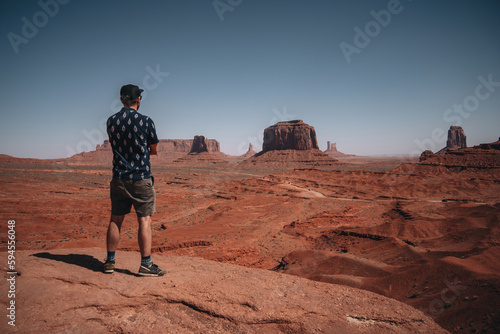 Tourist admiring view with of Monument Valley with mittens butte in the background. Travel and adventure concept. Navajo Nation  Arizona  USA.