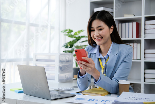Young asian woman using smartphone chatting video conference online sitting in living room at home. Business Woman shopping online by smartphone.