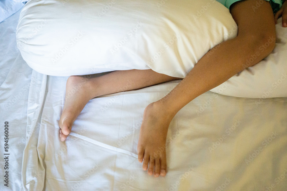 The little feet of a little girl hugging a pillow The little feet of a little girl hugging a pillow