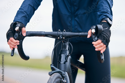 Hands of person, athlete and bicycle handlebar for training, triathlon sports and cardio fitness. Closeup, bike gear and cyclist holding lever, brakes and cycling outdoor for action, race and journey