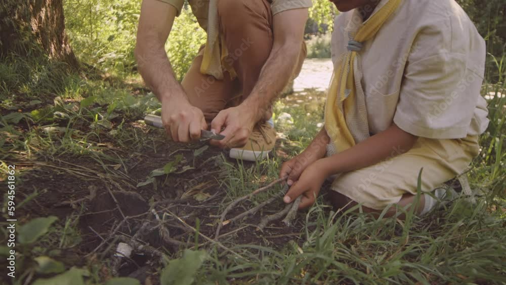 Scout Using Tool Adult Caucasian male scouter using knife and tree branch teaching young ...