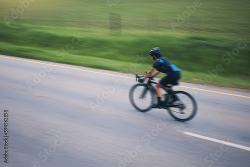 Person, cycling and speed with motion blur outdoor on bike in countryside of training, triathlon and sports power. Athlete, bicycle and marathon race of fitness, energy and performance on mockup road