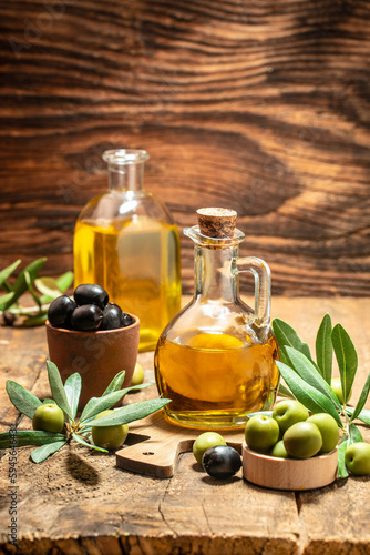 Olive oil and olive branch on a wooden background. place for text