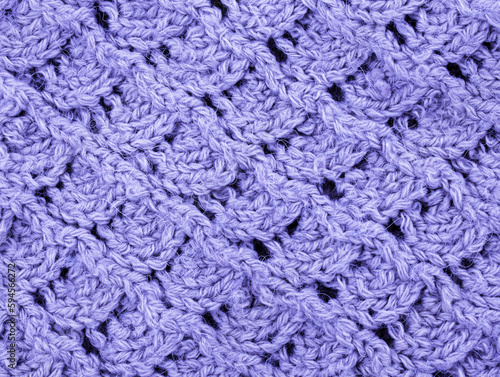 Purple Knitting pattern close-up. Knitting is an easy pattern for beginners. Texture of a knitted sweater. Warm thread pattern in the shape of a fan