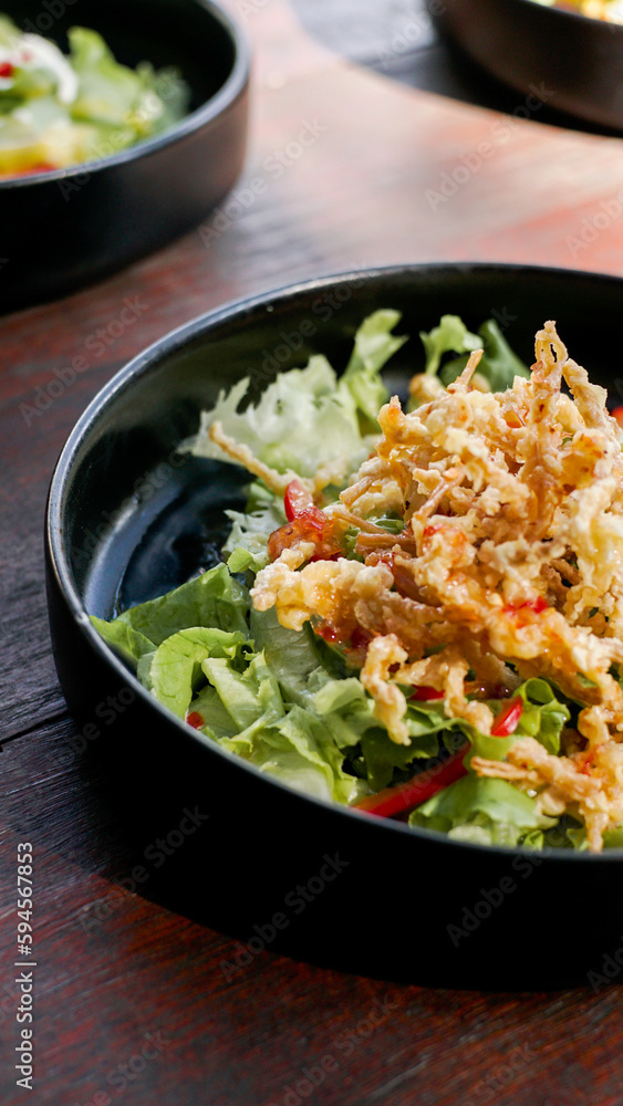 deep fried enoki mushroom or golden needle mushroom on top of green salad on black plate, vegan style
deep fried enoki mushroom or golden needle mushroom on top of green salad on black plate, vegan style