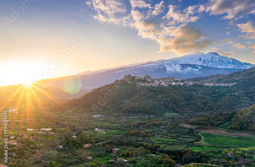 amazing mountain sunset landscape of green mountains and hills, old highland town and snow top mountain on backgroud