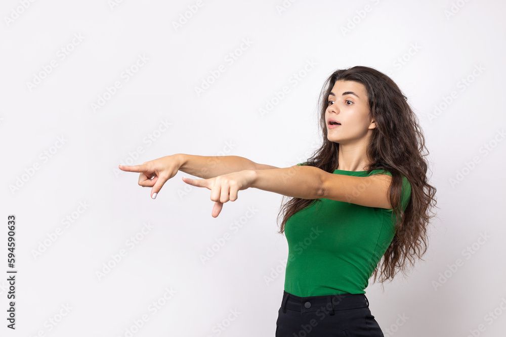 Happy young caucasian female in a shirt pointing fingers away Happy young caucasian female in a shirt pointing fingers away