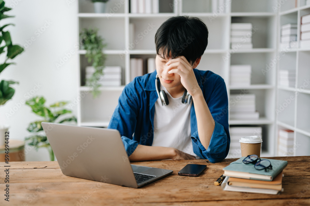 Asian business man is stressed, bored, and overthinking from working on a tablet at the office. Asian business man is stressed, bored, and overthinking from working on a tablet at the office.