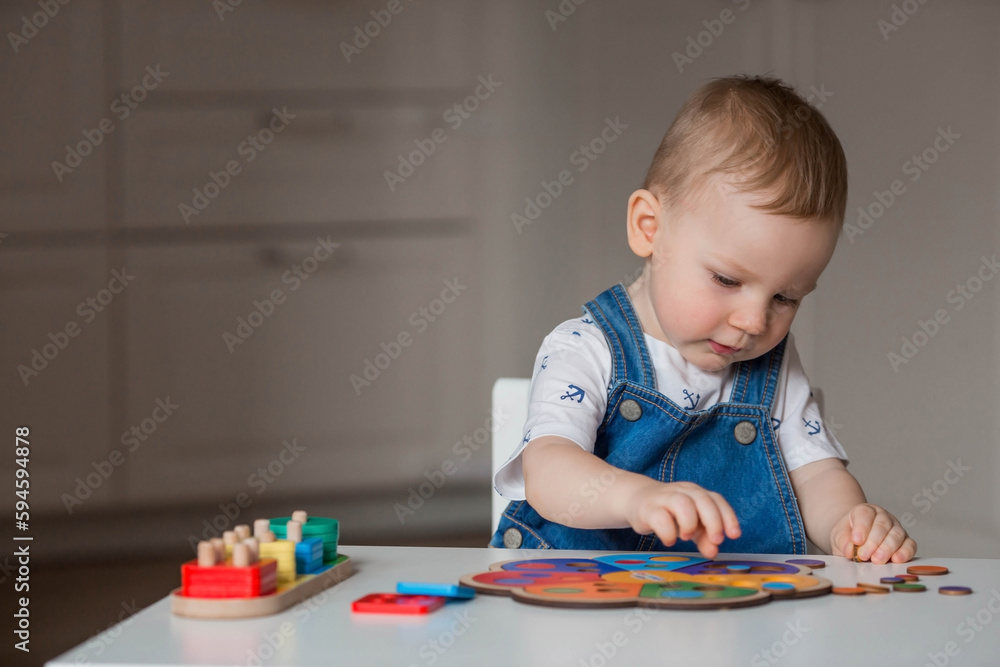 A little boy is playing educational logic games. Children's wooden toys. Sorter. Montessori for child development. A little boy is playing educational logic games. Children's wooden toys. Sorter. Montessori for child development.
