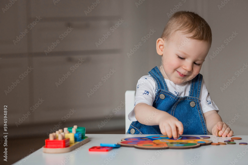 A little boy is playing educational logic games. Children's wooden toys. Sorter. Montessori for child development. A little boy is playing educational logic games. Children's wooden toys. Sorter. Montessori for child development.