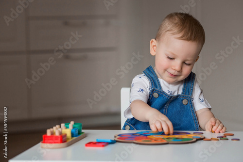 A little boy is playing educational logic games. Children's wooden toys. Sorter. Montessori for child development.