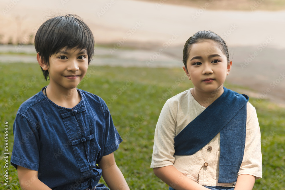 Portrait young Asian boy and girl in northern traditional Thai clothes Portrait young Asian boy and girl in northern traditional Thai clothes