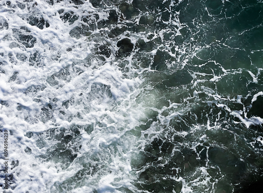 Naklejka premium Abstract, natural background. Sea waves. Top view, close-up. The seashore. Seascape. Cote d'Azur, the beach. The water is emerald-colored.