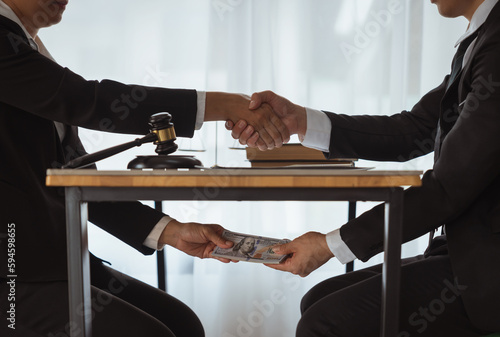 Foto business people shaking hands and Give an under-the-table bribe to an attorney to help a lawyer win a court case