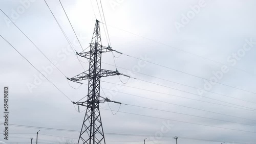 High voltage electric tower with wires on overcast sky background. Transmission power line. Parts of electrical equipment and high voltage power line insulators.