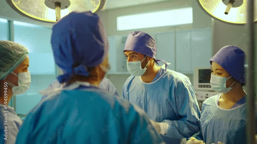 Male doctor talking with team during operation in theatre. Hospital, medical and healthcare services. Male doctor talking with team during operation in theatre. Hospital, medical and healthcare services.