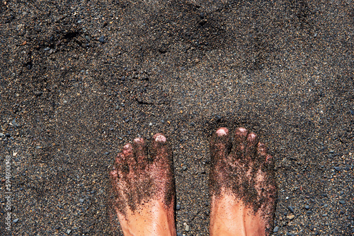 
Pies descalzos de un hombre en la playa cubierta de arena negra en la costa volcánica de Fuerteventura en las Islas Canarias. photo