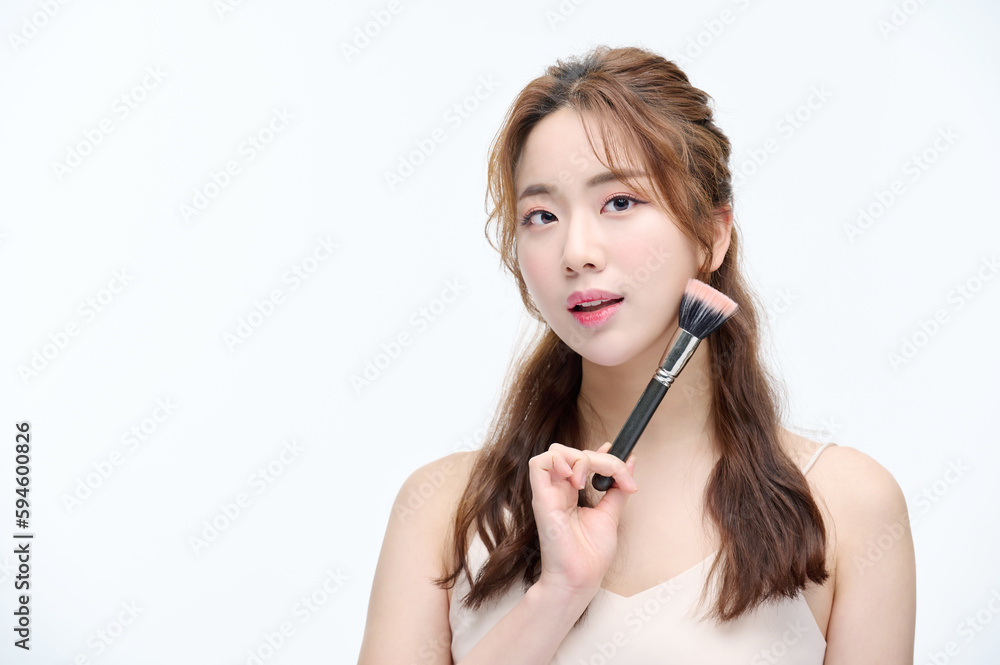 Beautiful Young Asian woman with clean fresh skin touching two hands on face in beauty pose. Pretty girl smiling in white background. cosmetology, make up concept with several brushes Beautiful Young Asian woman with clean fresh skin touching two hands on face in beauty pose. Pretty girl smiling in white background. cosmetology, make up concept with several brushes