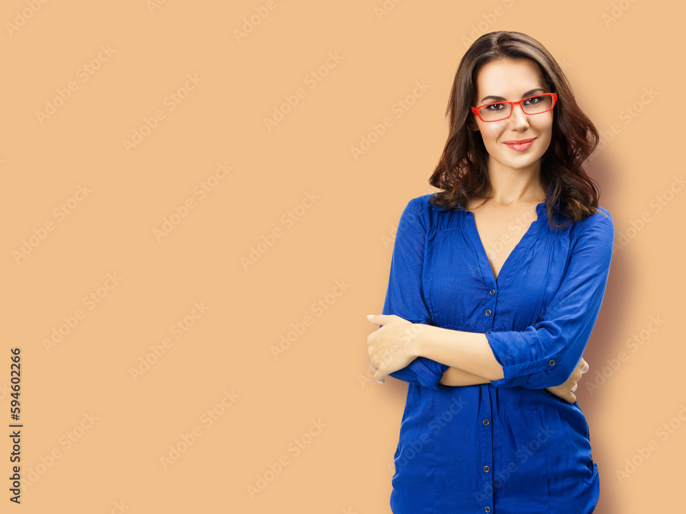 Portrait of happy smiling young brunette woman in red eye glasses, blue confident wear, isolated latte beige background. Business studio concept. Copy space blank area for text. Portrait of happy smiling young brunette woman in red eye glasses, blue confident wear, isolated latte beige background. Business studio concept. Copy space blank area for text.