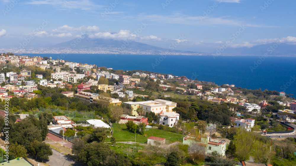 Aerial view of Posillipo district in the city of Naples, Campania, Italy. In the background the volcano Vesuvius dominates the landscape.