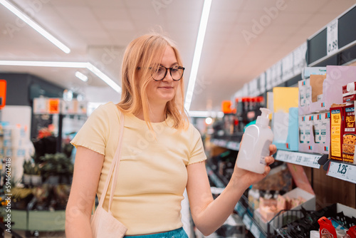Women choosing a dairy products at supermarket. Reading product information. High quality photo