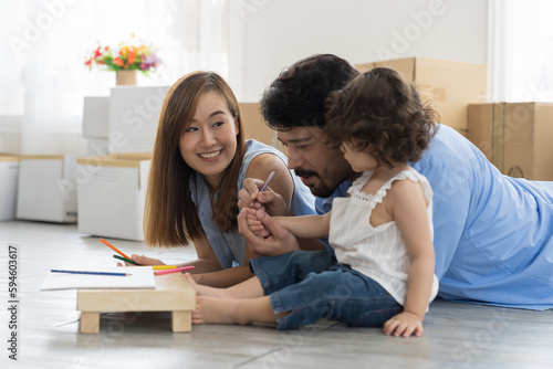 Moving house, mortgage, family and real estate concept. Happy family, father, mother and cute little daughter baby toddler girl playing and spending time together while moving into new house